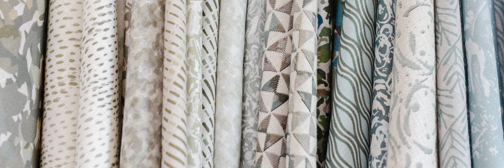Collection of small-batch fabric wings in neutral colors hanging in Emily Daws Showroom.