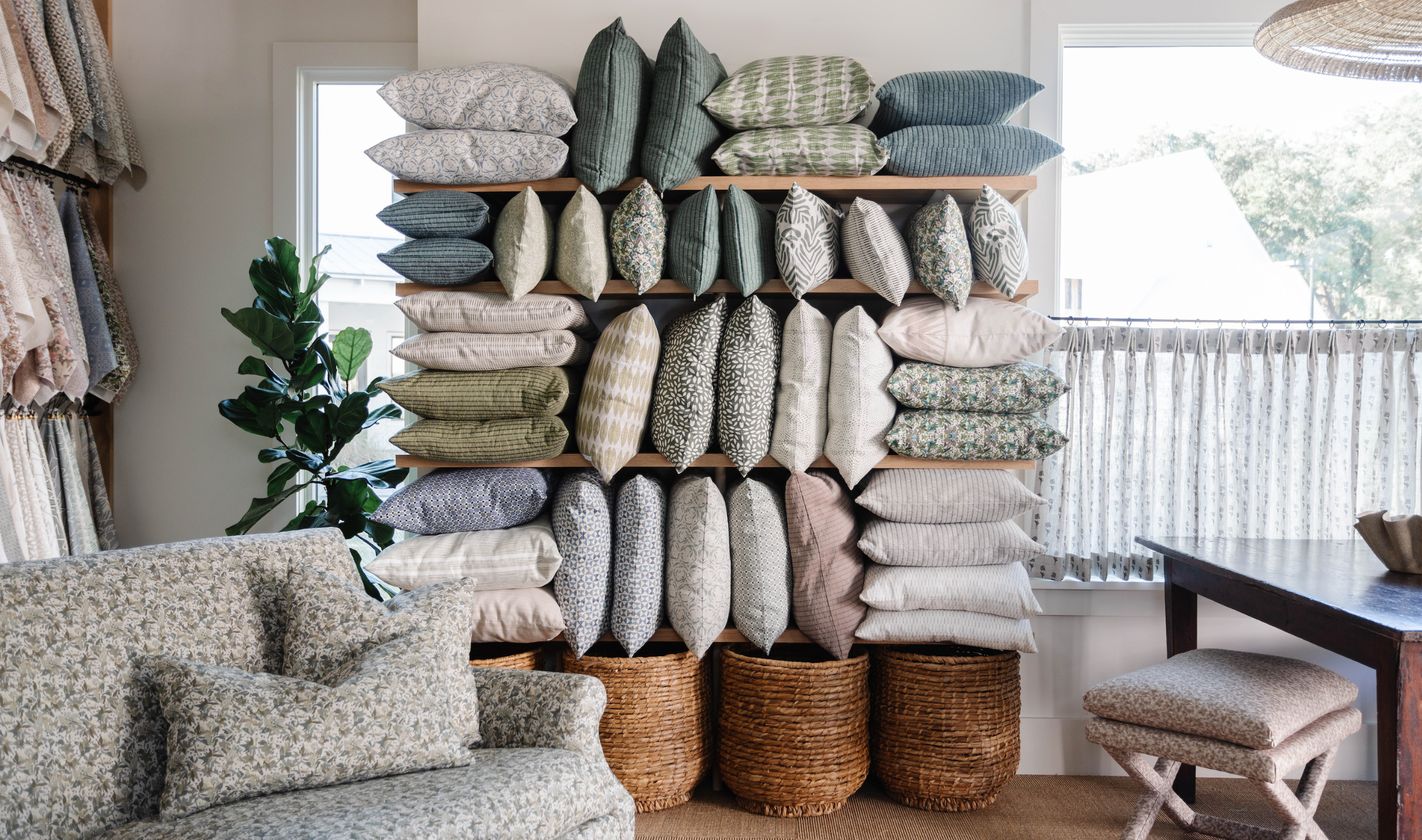 Stack of decorative pillows in various patterns, designed by Emily Daws in her Charleston Showroom.