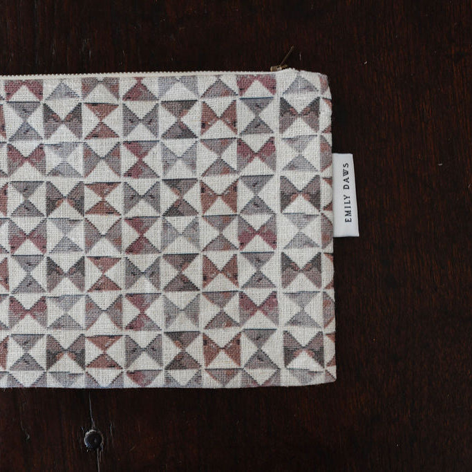 Fabric with geometric pattern and 'EMILY DAWES' label on a dark surface