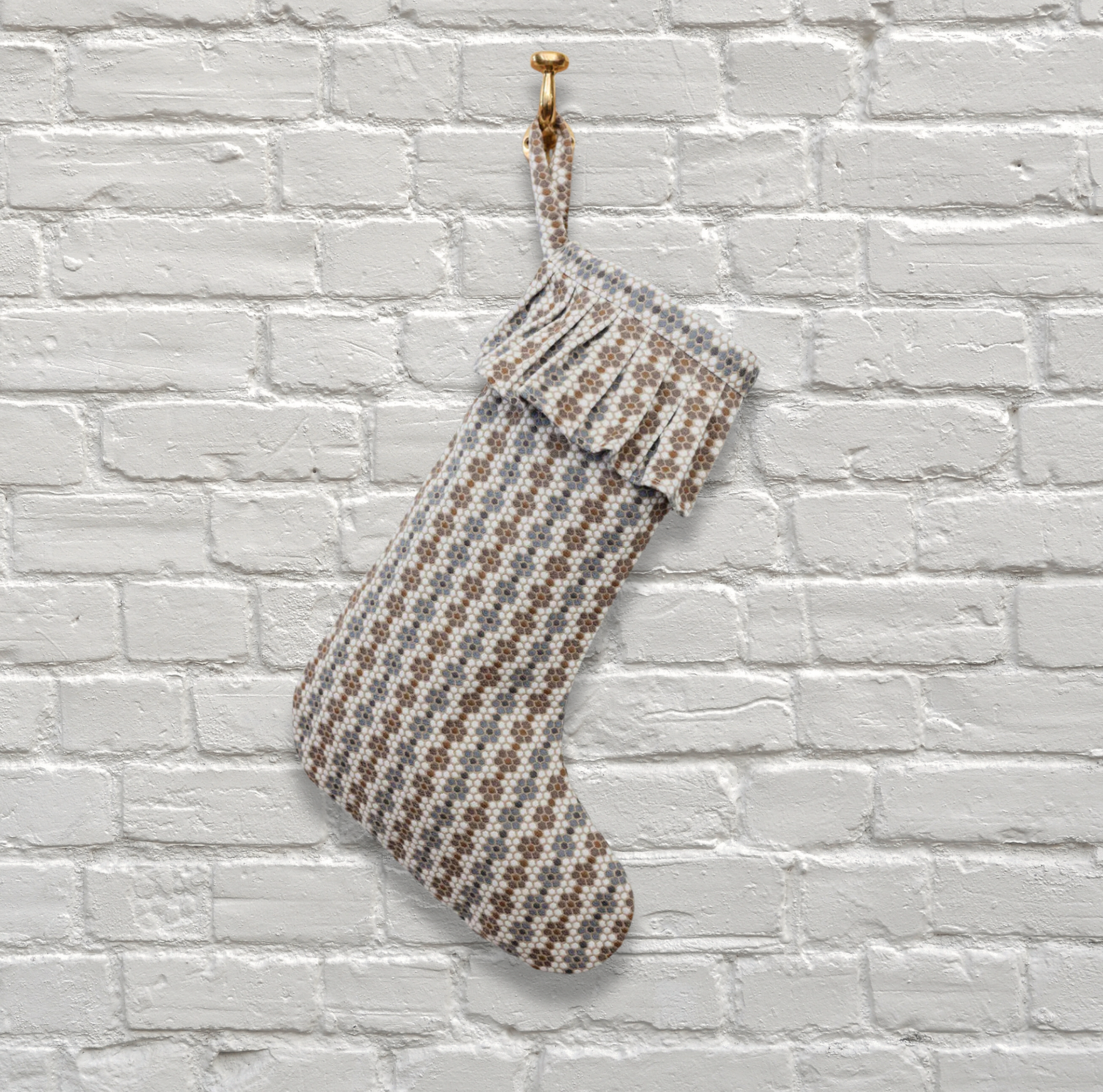 Nectar Christmas stocking by Emily Daws hanging on a white brick wall.