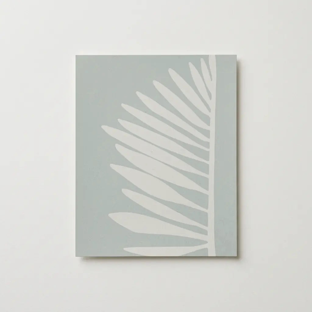 A minimalist palm patttern wallpaper by Emily Daws featuring a stylized white palm leaf on a muted blue green background, shown as aswatch.