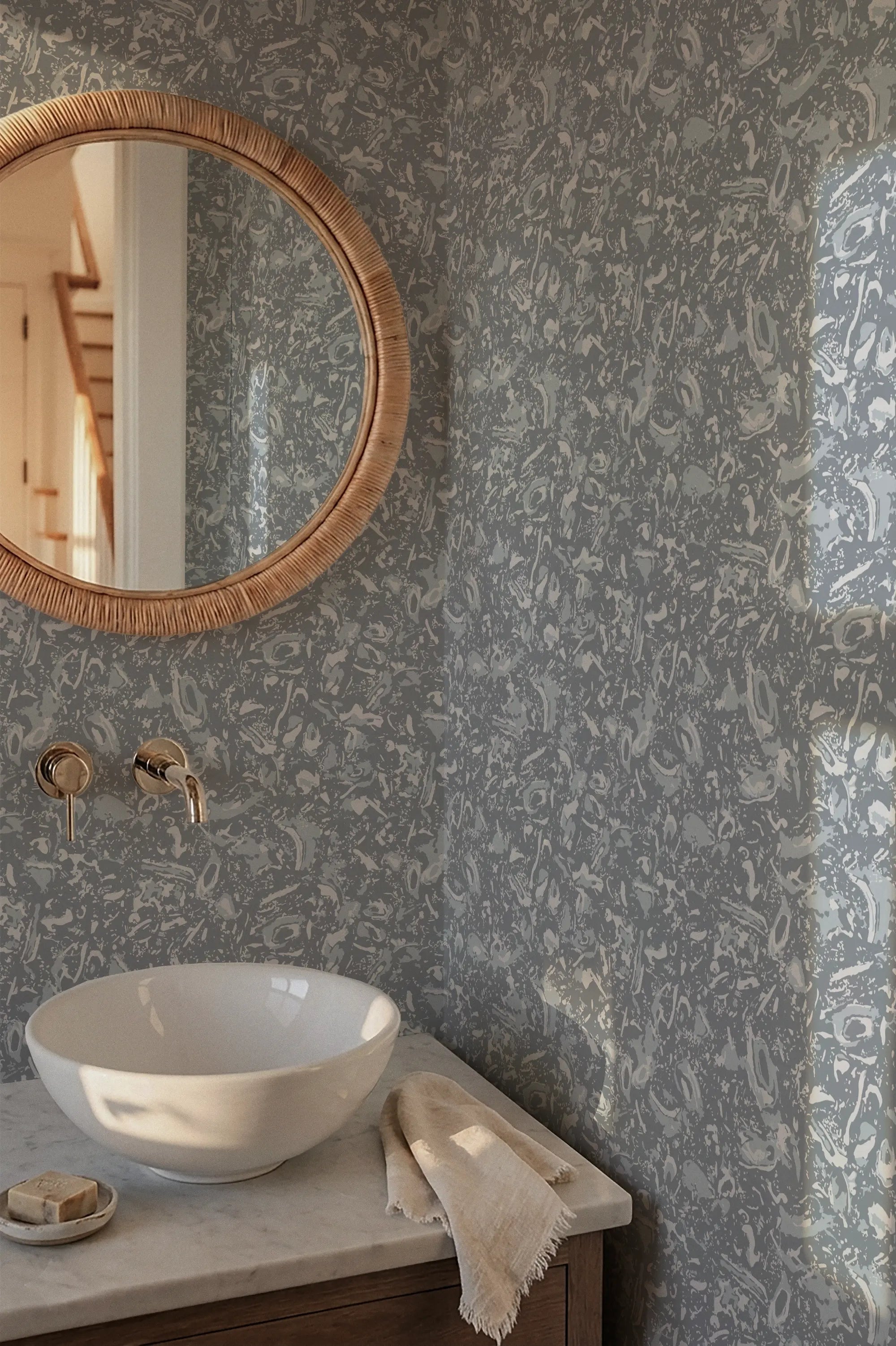 Bathroom with round mirror, white sink, and textured gray wall.