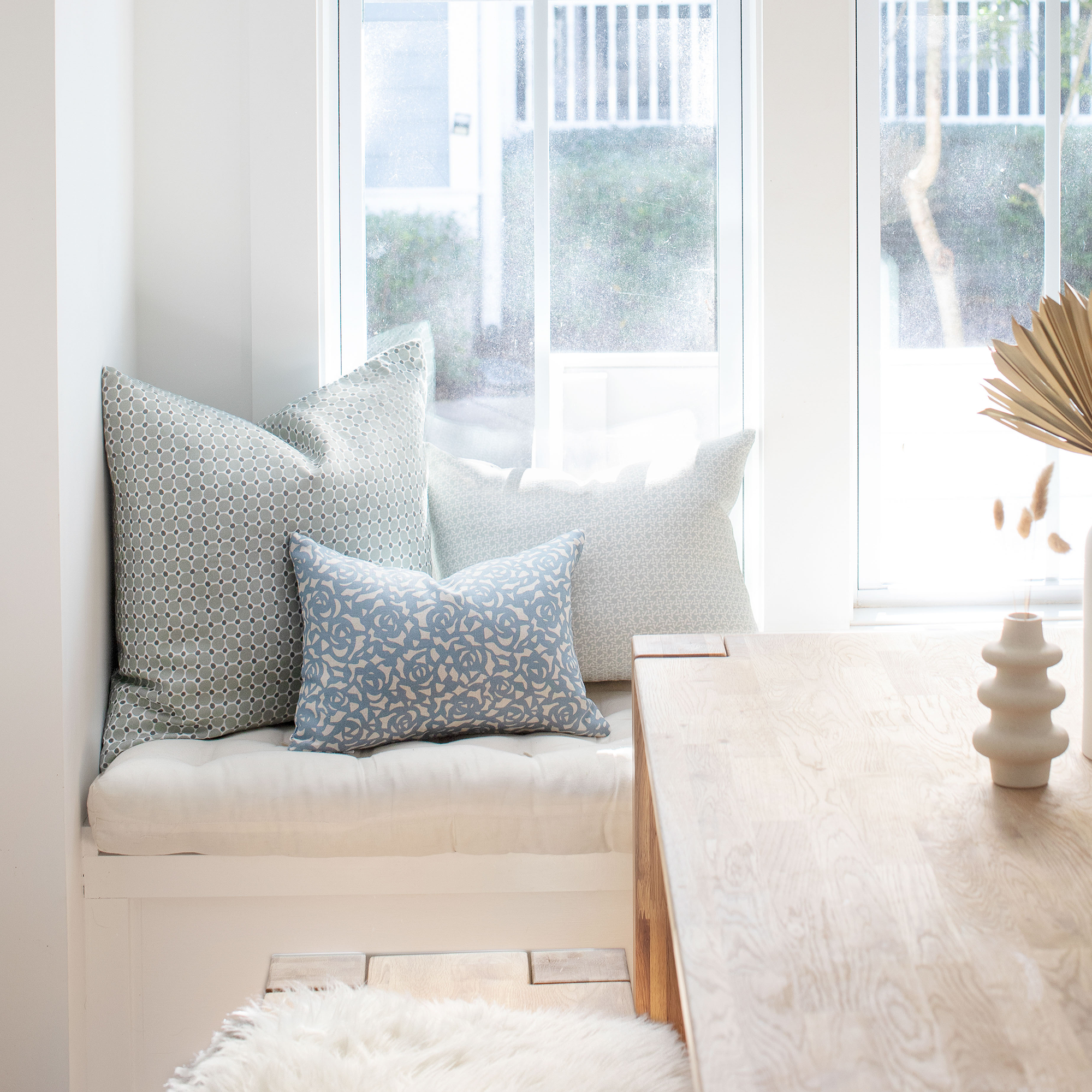 Carolina Rice pillow in Pear styled by Emily Daws – placed on a vintage settee in a Charleston cottage