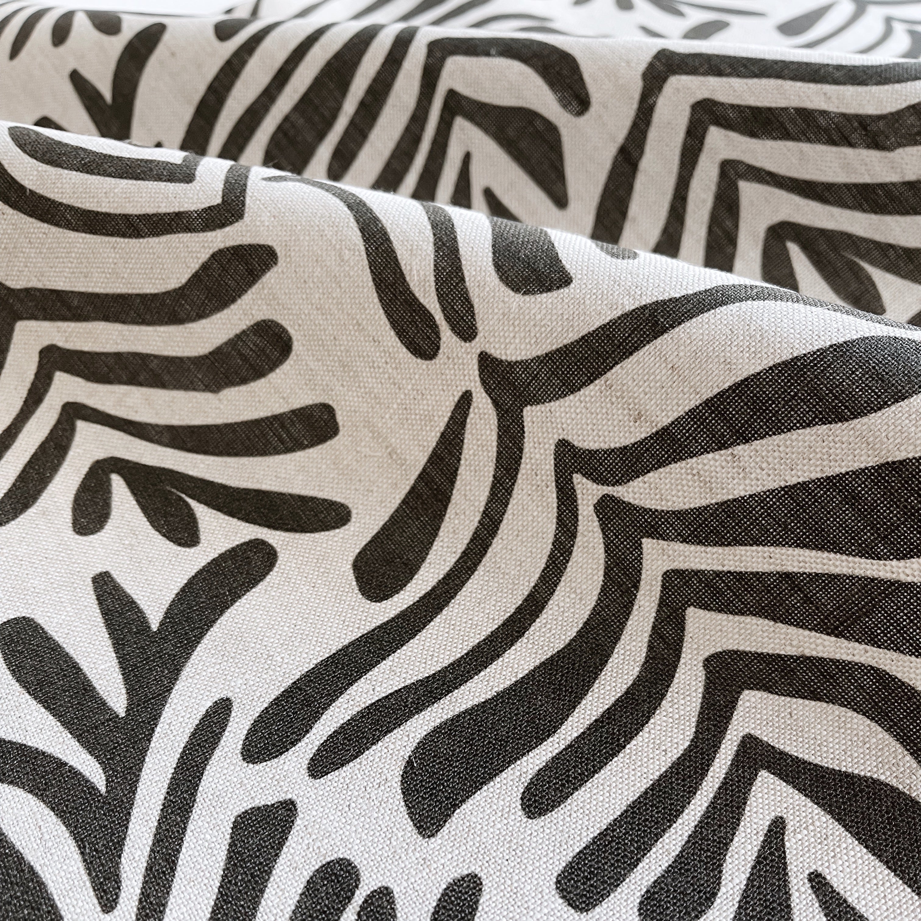 Frond fabric in Crow – close-up of linen texture and leafy pattern; perfect for pattern sofas