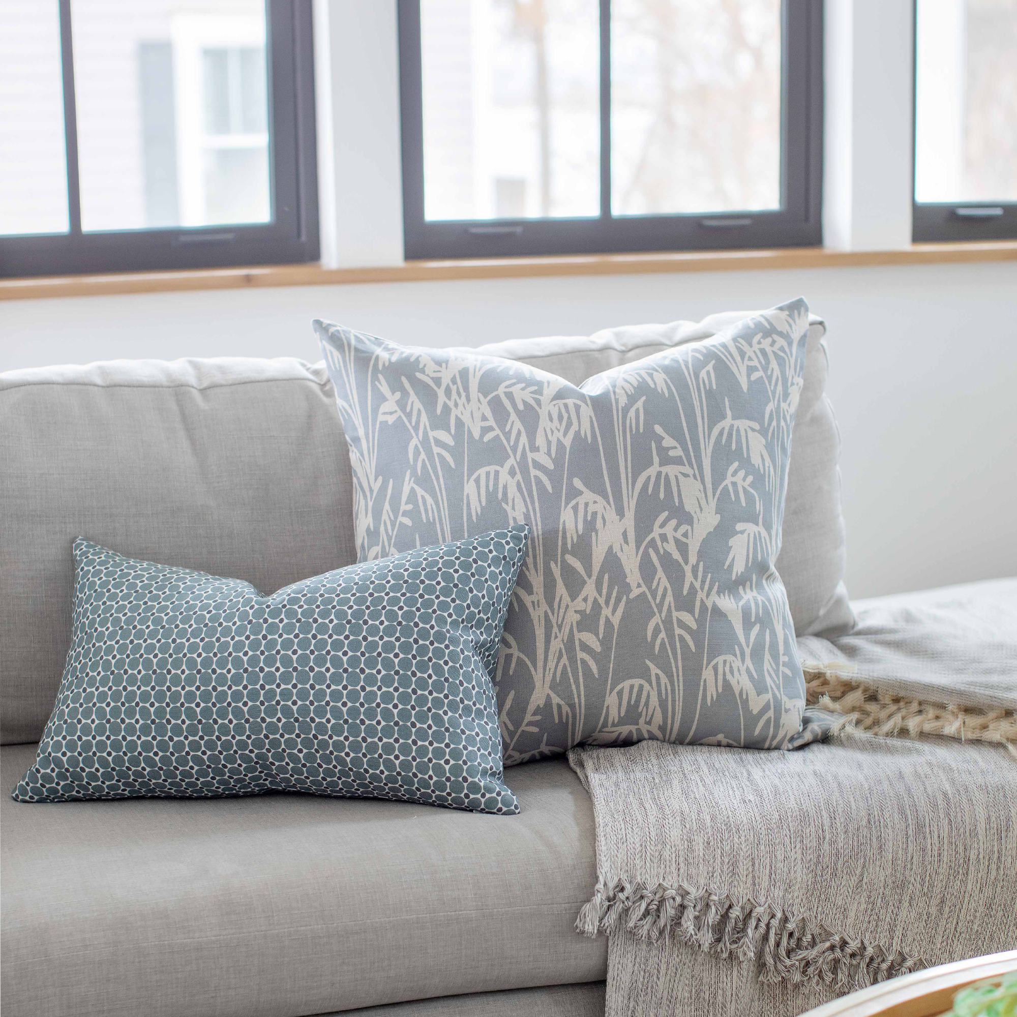 Emily Daws pillows styled in a living room with layered fabrics and patterns, designed for luxury interiors.