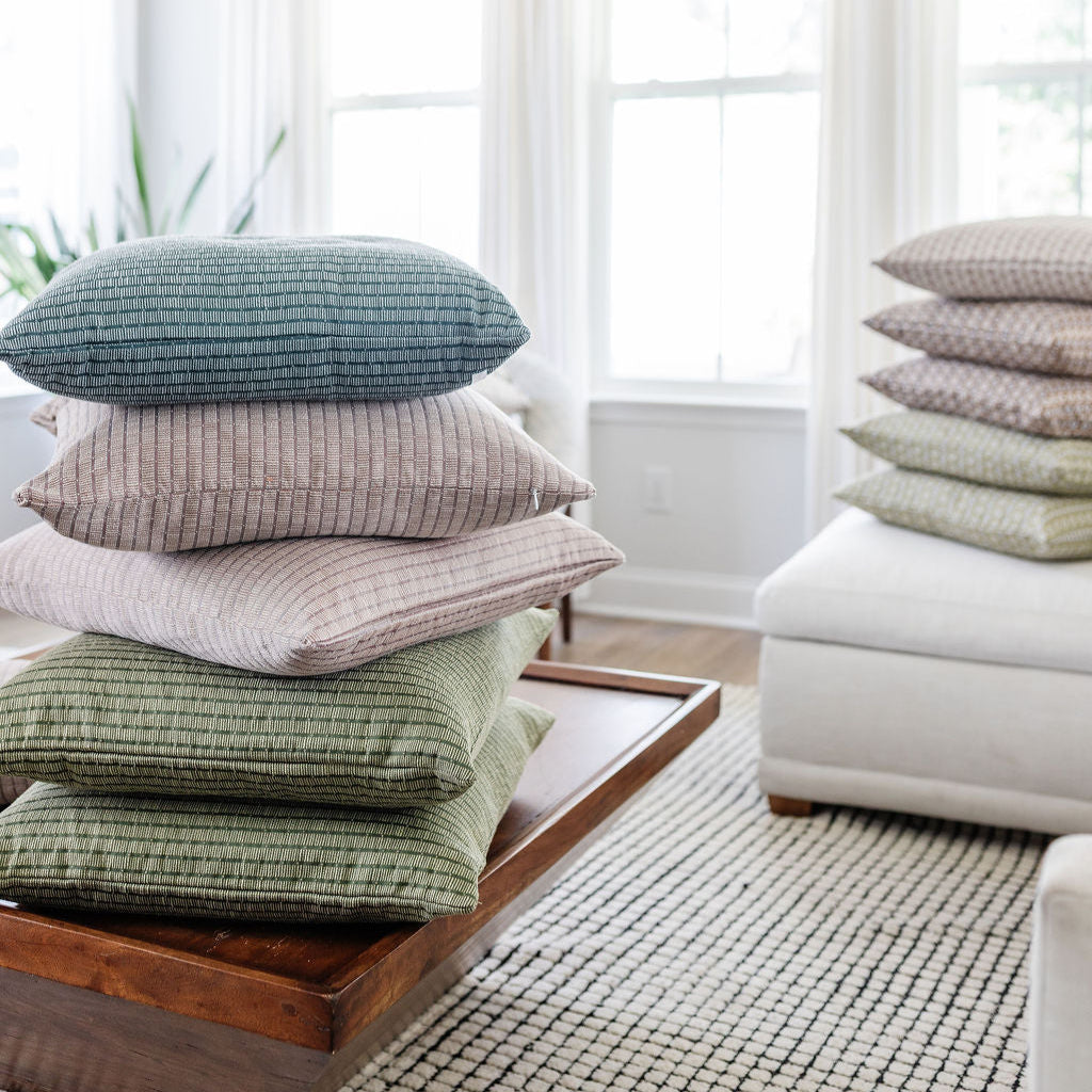 A curated stack of Emily Daws pillows showcasing boutique fabrics and layered design details.