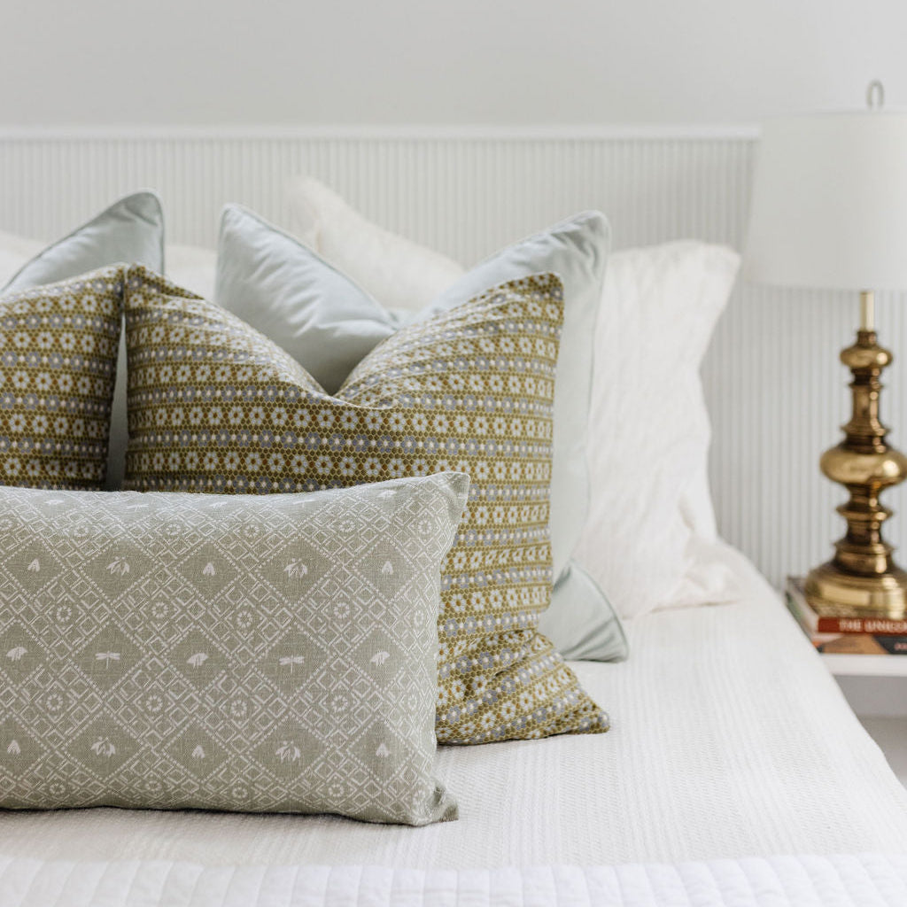 Bedroom vignette featuring Emily Daws pillows, styled with heirloom-inspired fabrics for boutique interiors.