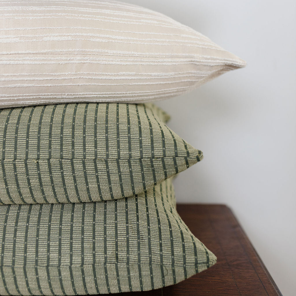 Emily Daws Jetty Palm pillow stacked with other woven fabrics, small batch textiles for bespoke interiors and custom pillows.