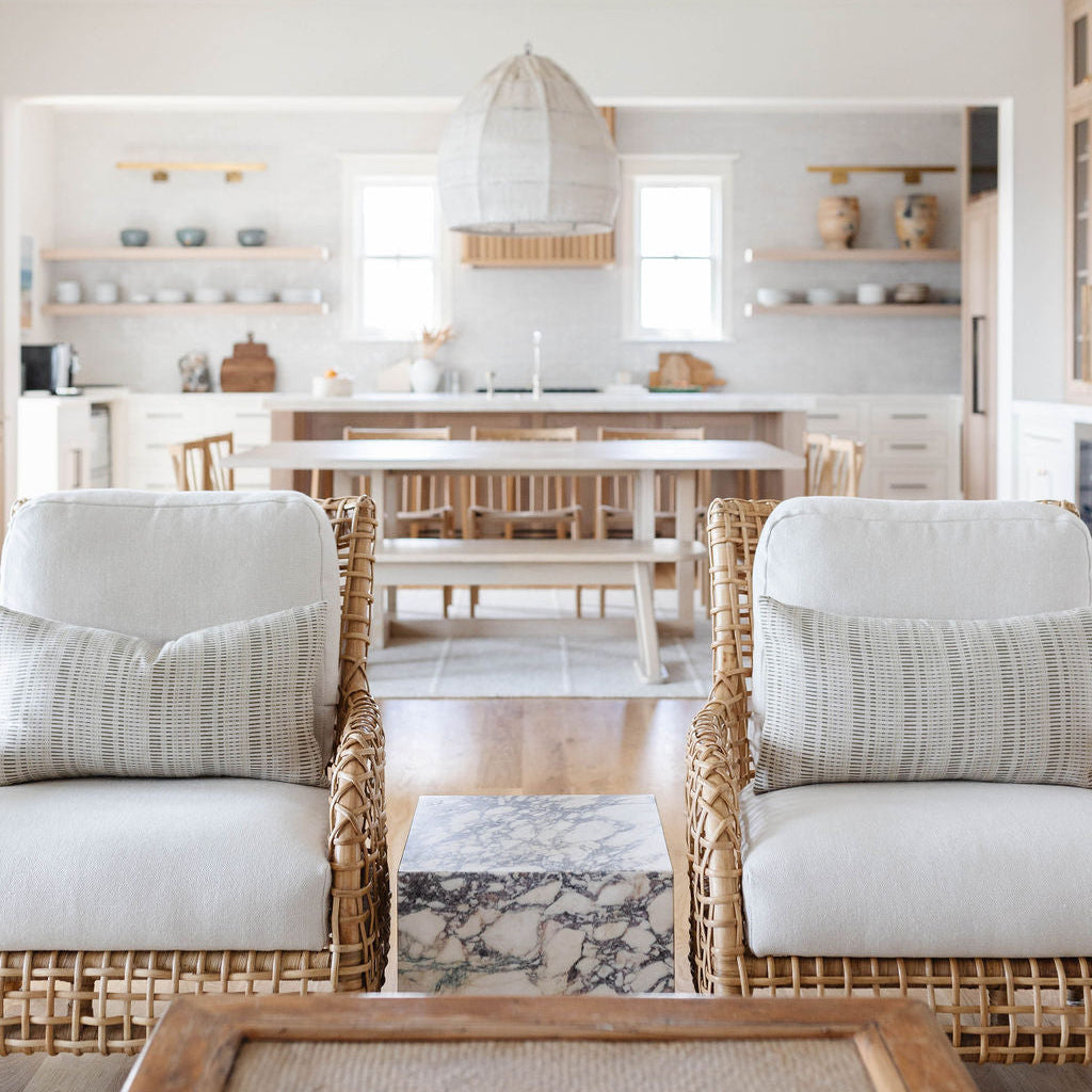 Armchair styled with Emily Daws pillows, featuring handcrafted details and linen fabrics for classic interiors.