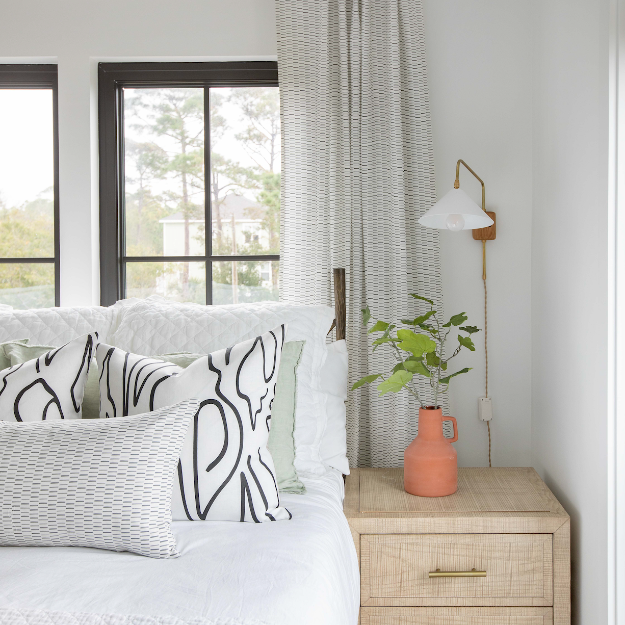 Emily Daws throw pillows layered on a bed, showcasing luxury textiles and heirloom-inspired patterns for designers.