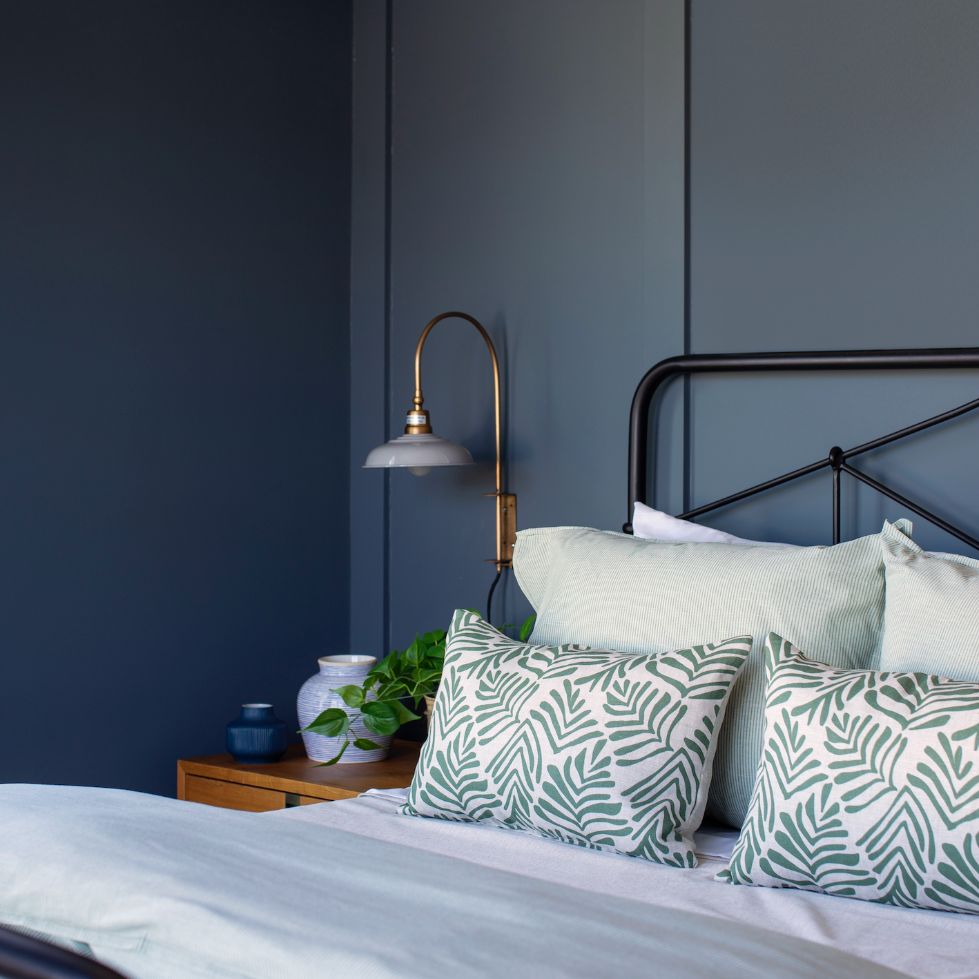 Emily Daws throw pillows layered on a bed, showcasing luxury textiles and heirloom-inspired patterns for designers.