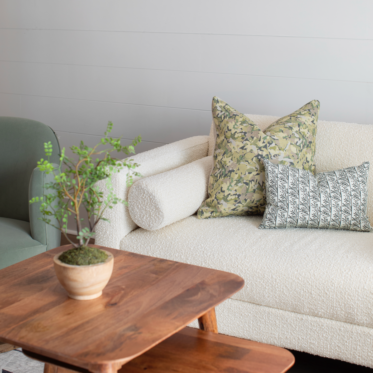 Sofa styled with Emily Daws pillows in artisanal fabrics, offering layered texture and color for interior designers.