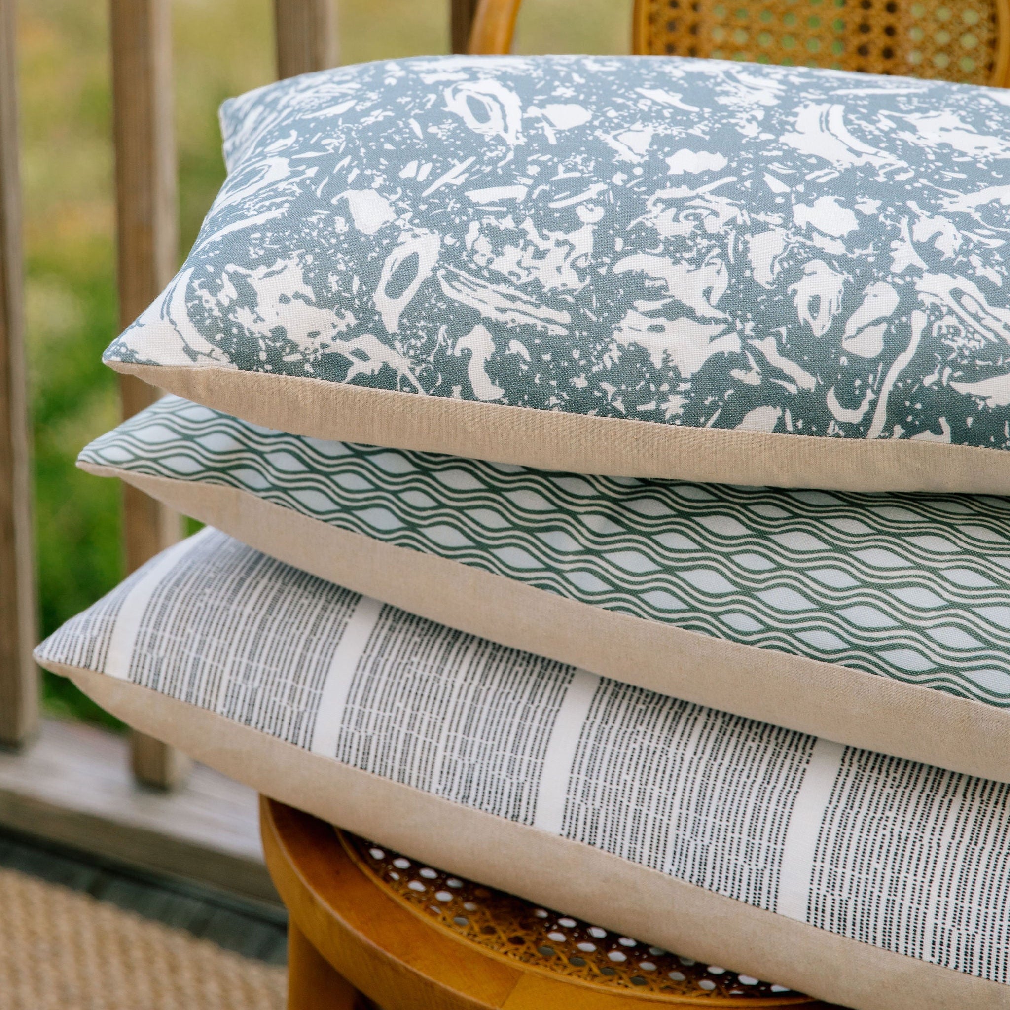 Emily Daws throw pillows stacked, showcasing luxury textiles and heirloom-inspired patterns for designers.