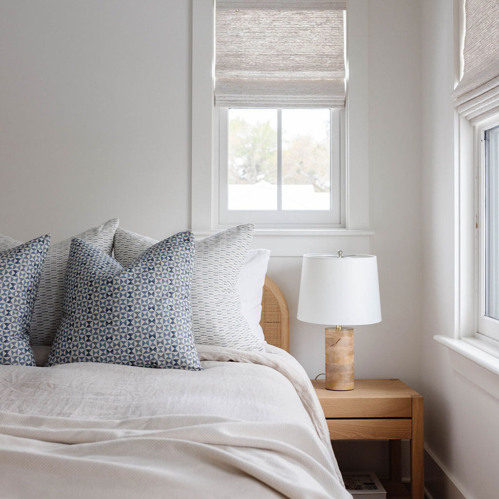Bedroom vignette featuring Emily Daws pillows, styled with heirloom-inspired fabrics for boutique interiors.

