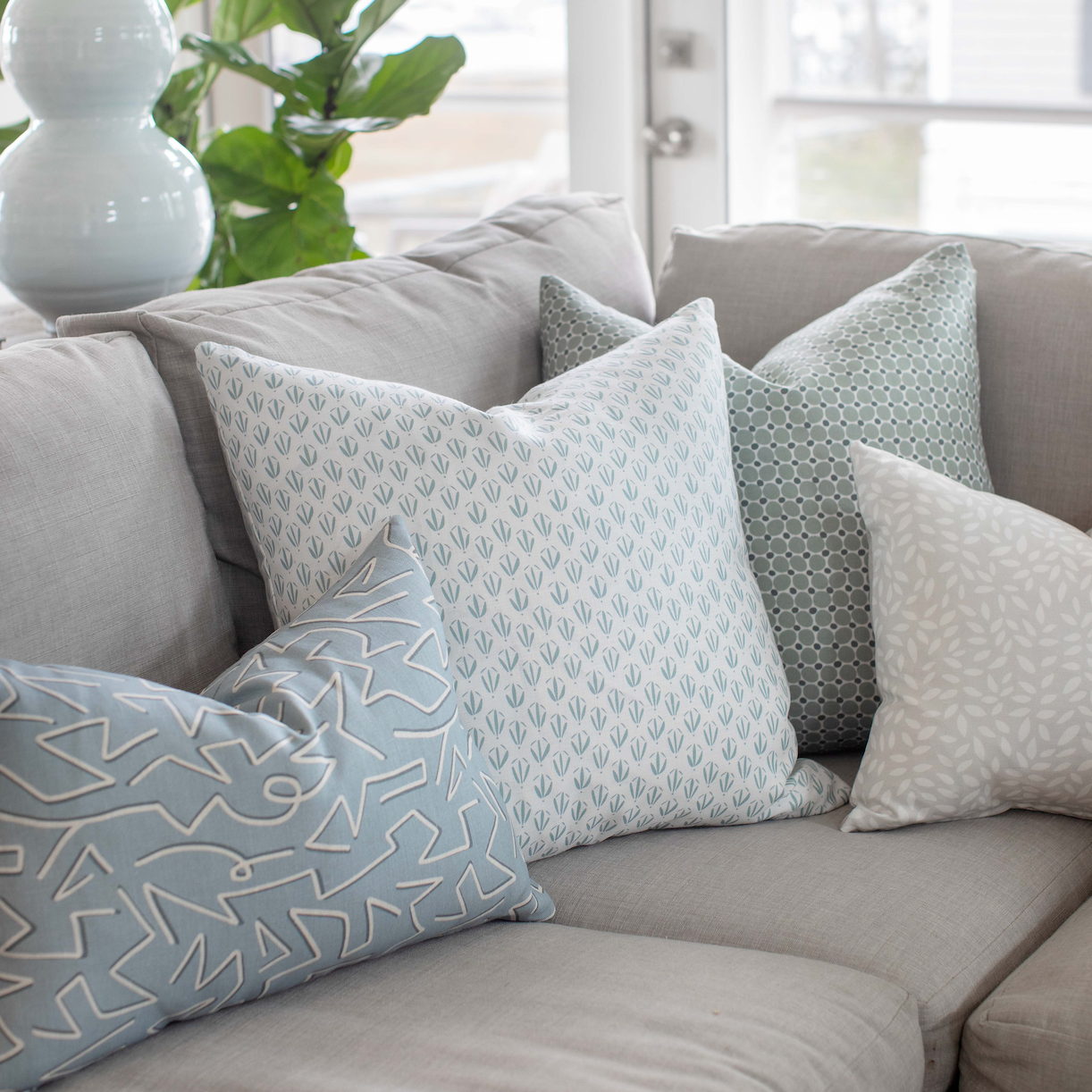 Emily Daws pillows styled in a living room with layered fabrics and patterns, designed for luxury interiors.