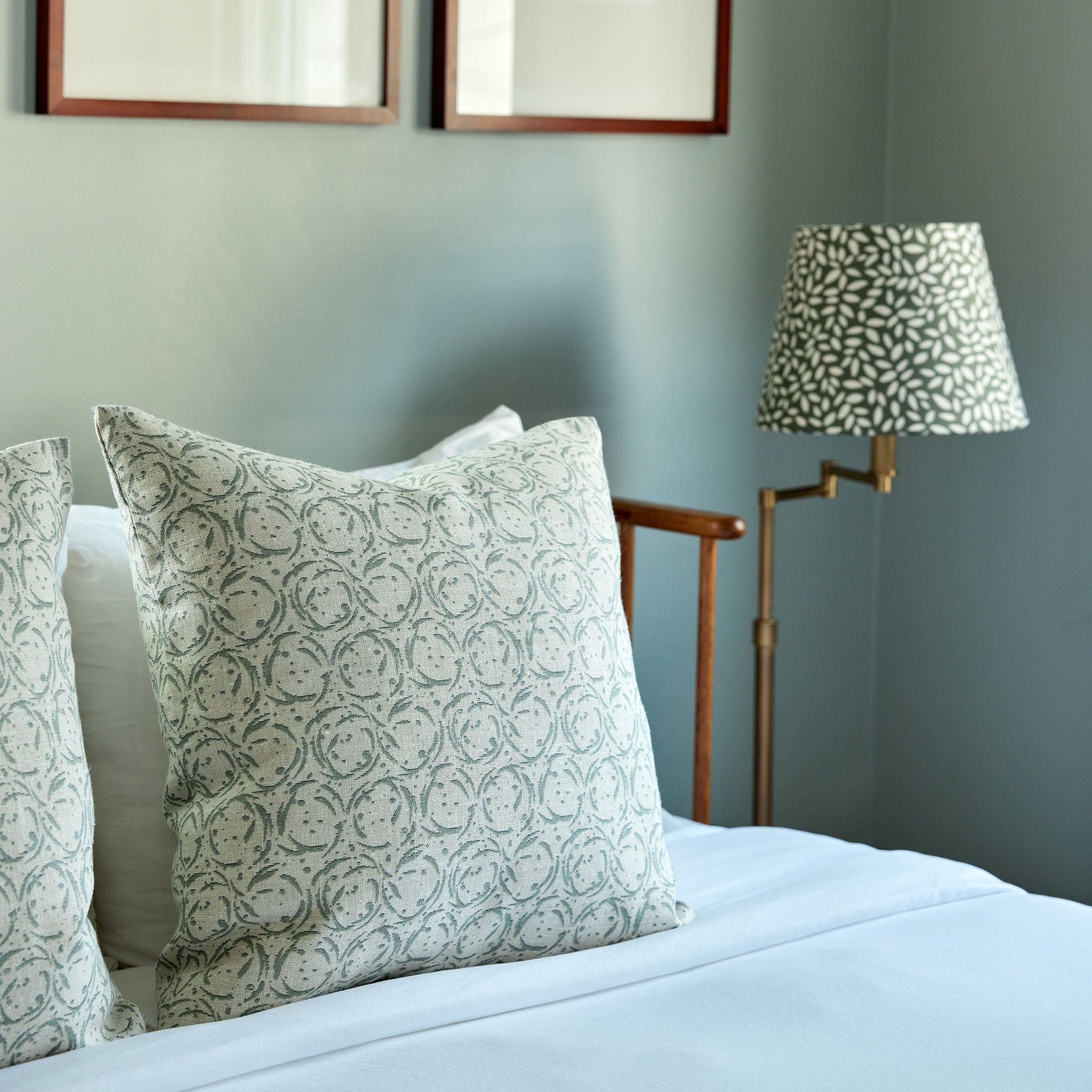 Bedroom vignette featuring Emily Daws pillows, styled with heirloom-inspired fabrics for boutique interiors.