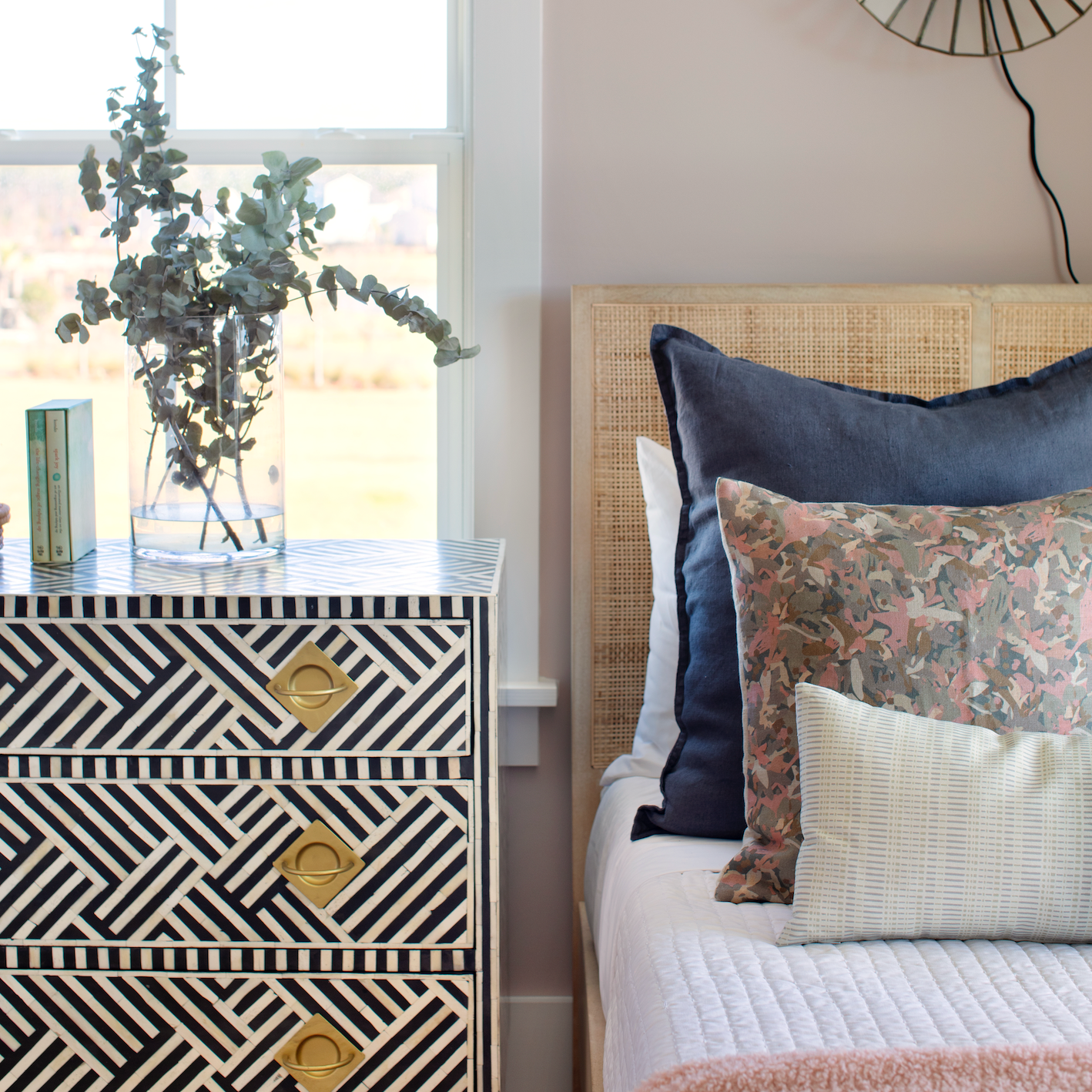 Bedroom vignette featuring Emily Daws pillows, styled with heirloom-inspired fabrics for boutique interiors.
