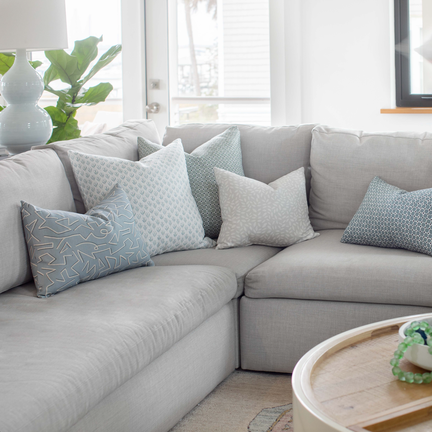 Emily Daws pillows styled in a living room with layered fabrics and patterns, designed for luxury interiors.