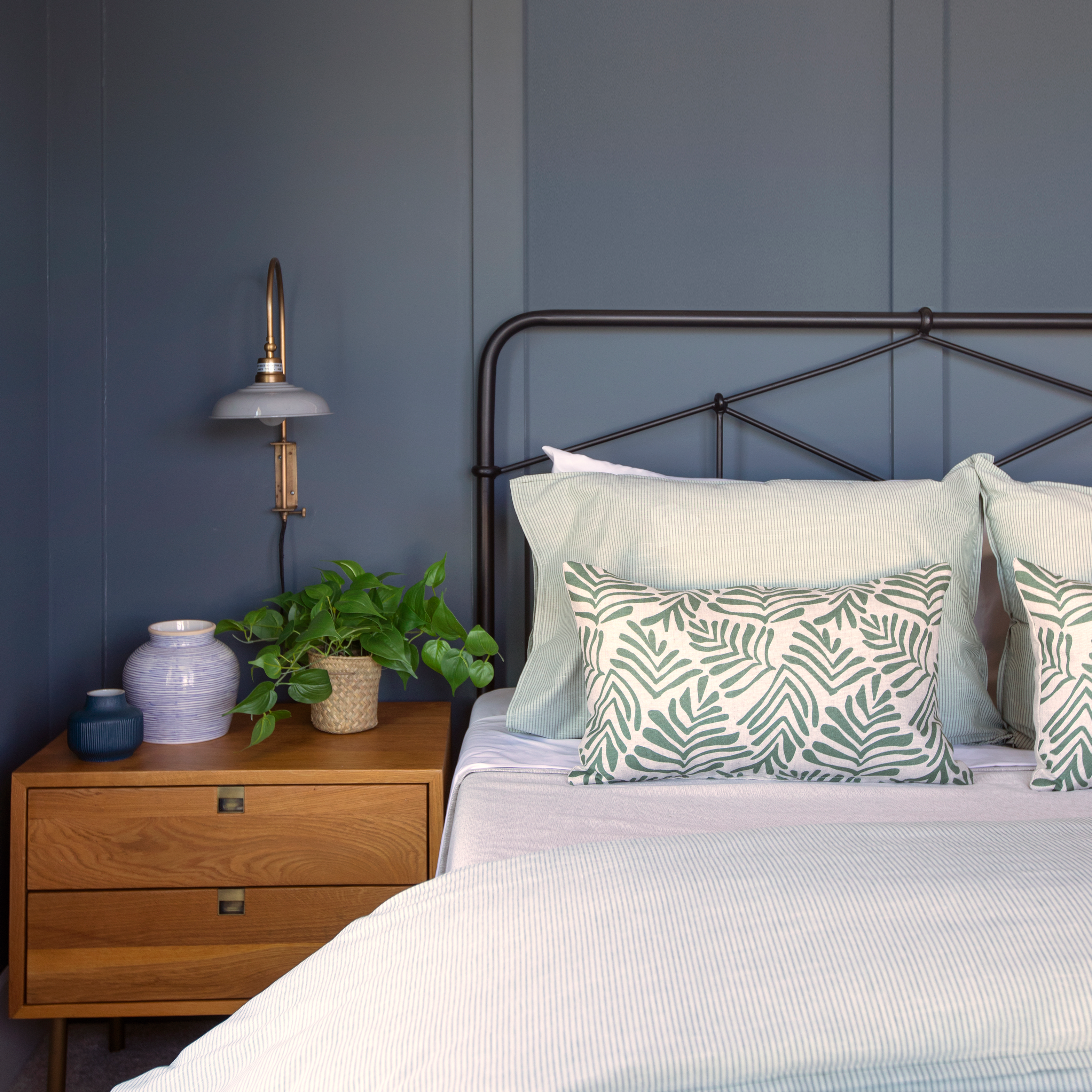 Frond pillow in Alpine styled by Emily Daws – layered with quilts in a woodland bedroom setting