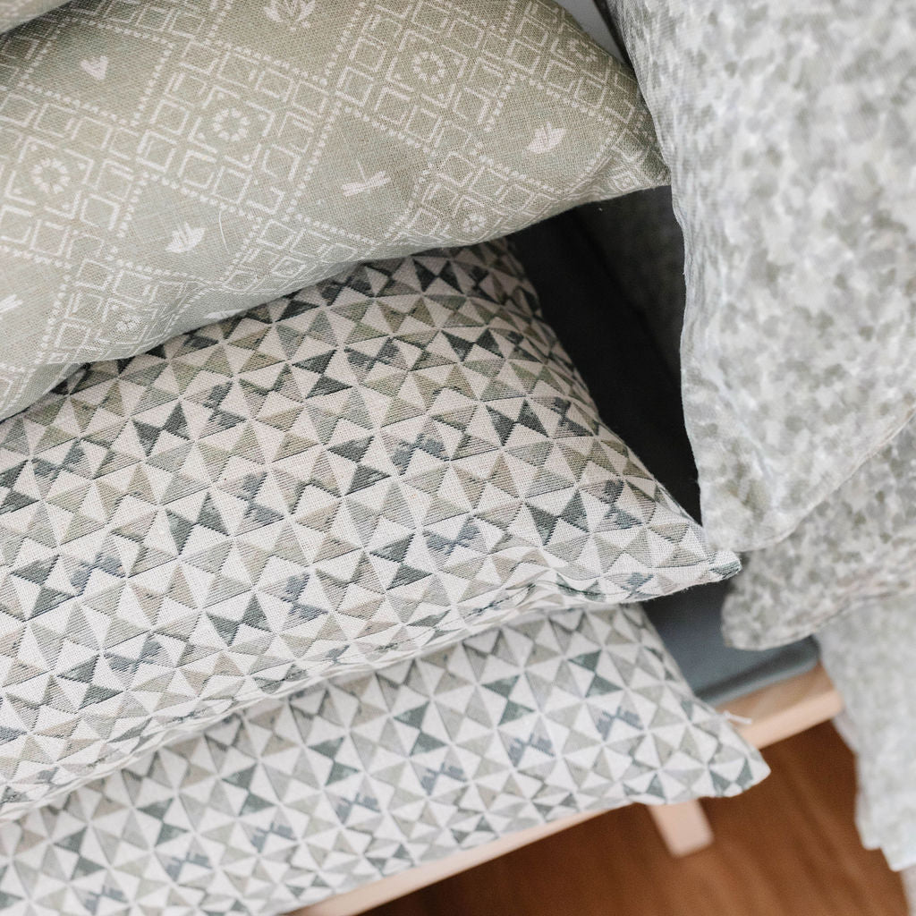 Kaleidoscope pillow in Ivy styled by Emily Daws – shown on a rustic bench with handmade quilts