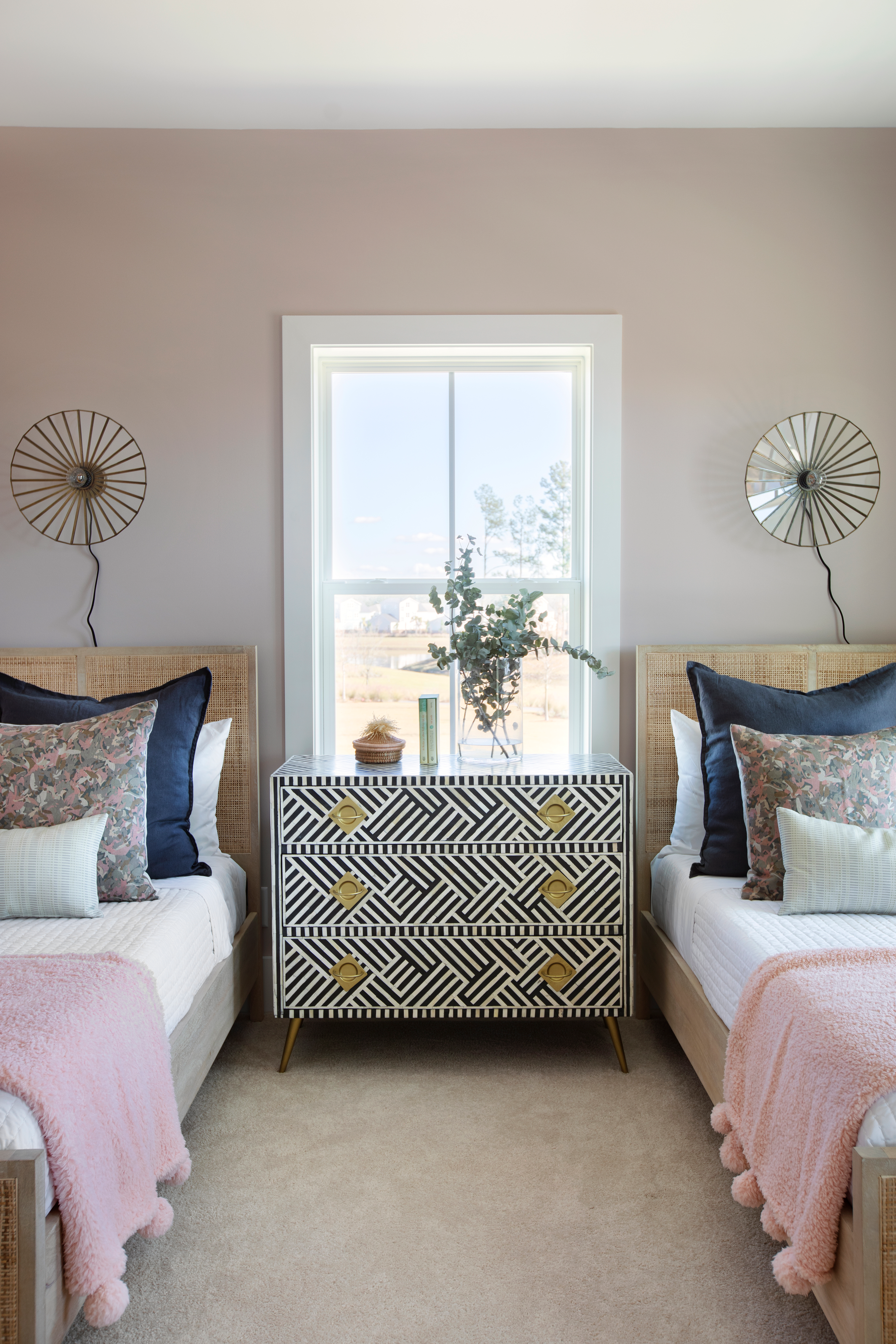 Thicket pillow in Rouge styled by Emily Daws – layered with quilts in a woodland bedroom setting