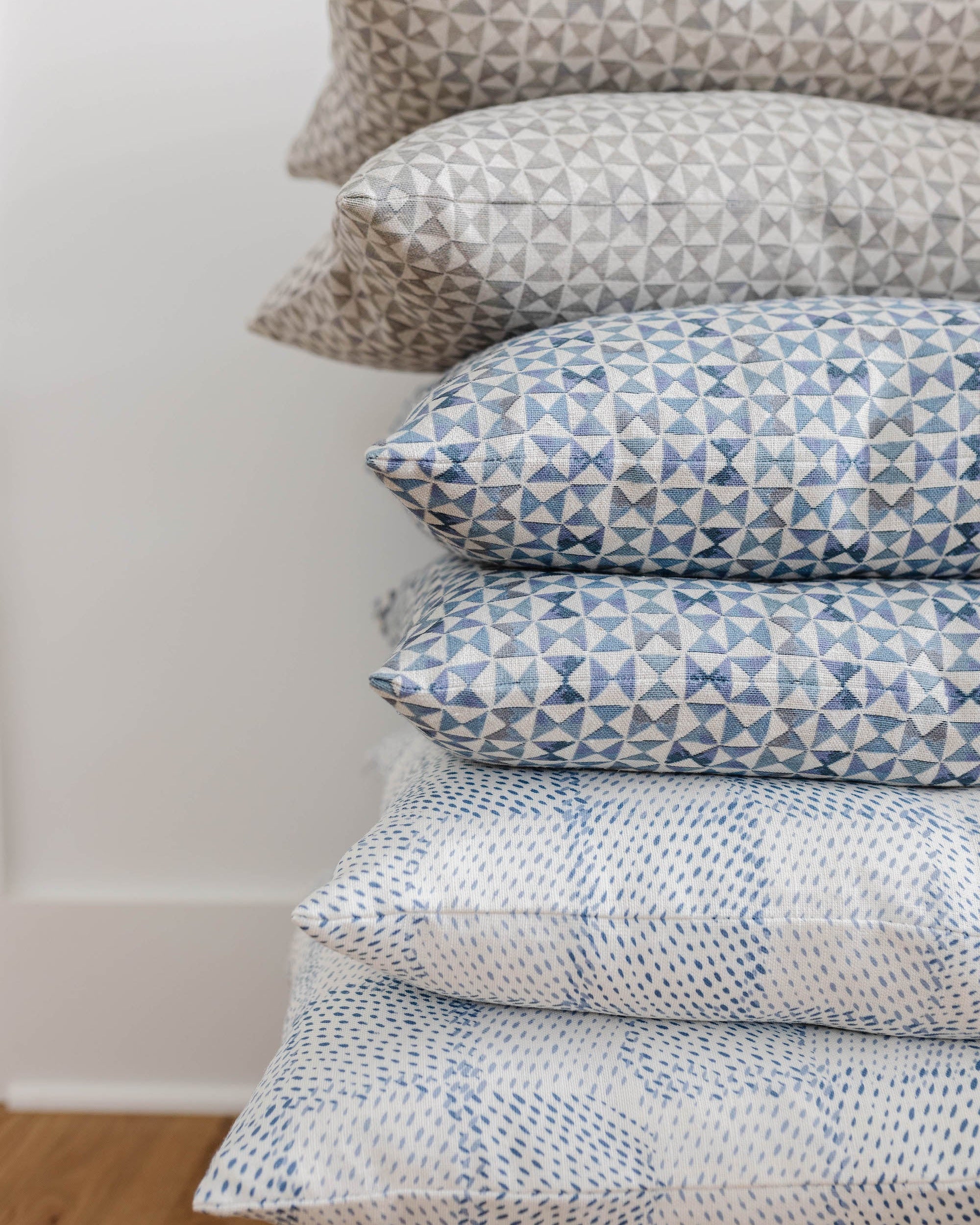 Stack of patterned pillows by Emily Daws on a plain background