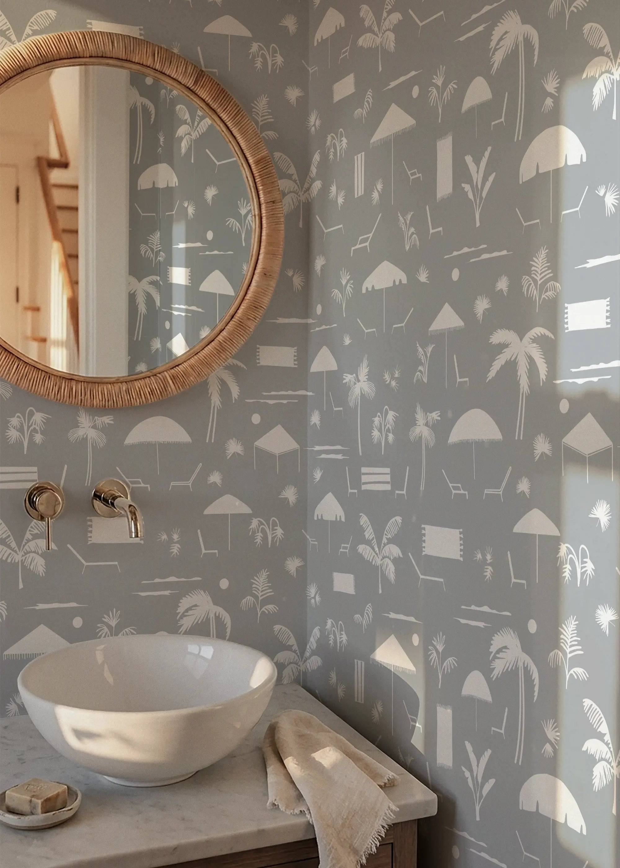 Bathroom with Folly Toile beach patterned wallpaper by Emily Daws, round mirror, and white sink in a Charleston home.