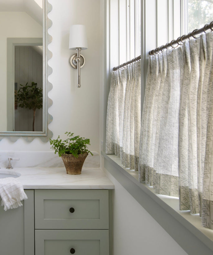 Bathroom with a vanity, mirror, and window with Emily Daws cafe curtains in the Southern Living Idea House, Kiawah River.